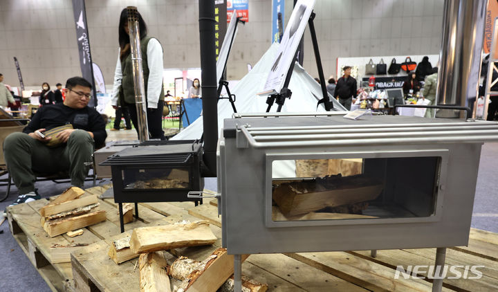 [고양=뉴시스] 전진환 기자 = 24일 오후 경기도 고양시 킨텍스에서 열린 '2023 국제아웃도어캠핑&레포츠페스티벌(GOCAF)'를 찾은 관람객들이 화목난로를 살펴보고 있다 2023.11.24. amin2@newsis.com