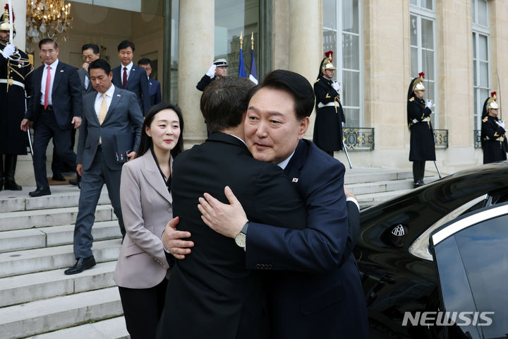 [파리=뉴시스] 전신 기자 = 2030 부산세계박람회 유치 활동을 위해 프랑스를 방문 중인 윤석열 대통령이 24일(현지시간) 파리 엘리제궁에서 열린 한·프랑스 조찬 겸 정상회담을 마친 뒤 에마뉘엘 마크롱 대통령과 포옹으로 인사하고 있다. (공동취재) 2023.11.24. photo1006@newsis.com