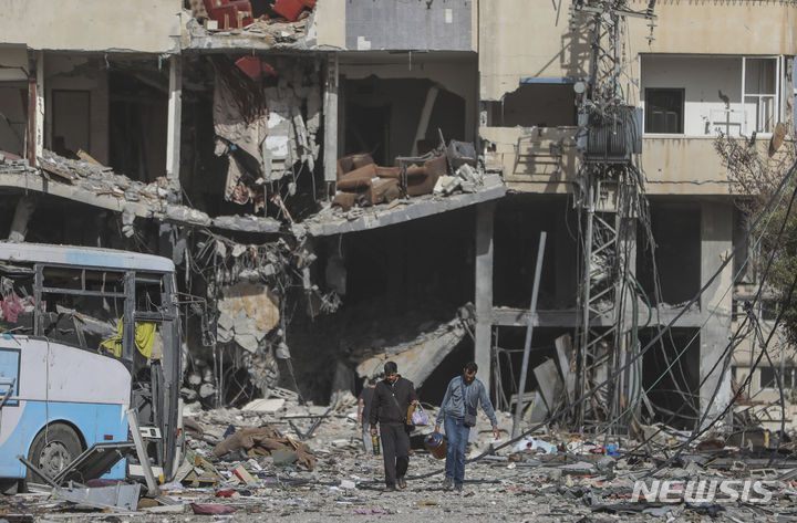 [가자지구=AP/뉴시스] 휴전 3일째인 지난 2023년 11월 26일(현지시각) 가자지구 내 가자시티 팔레스타인 주민들이 폐허 속에서 쓸만한 물건을 찾아 옮기고 있다. 2023.11.27. 