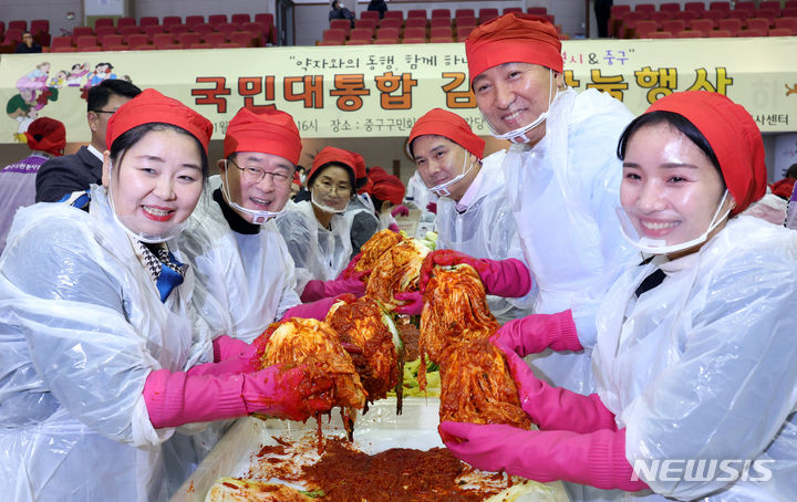 [서울=뉴시스] 최진석 기자 = 오세훈 서울시장이 27일 서울 중구구민회관에서 열린 국민대통합 김장나눔 행사에서 참석자들과 직접 담근 김치를 들어 보이고 있다. 2023.11.27. myjs@newsis.com