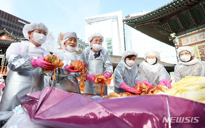 [서울=뉴시스] 김선웅 기자 = 조계사 주지 원명스님(왼쪽 두 번째부터)과 정문헌 종로구청장이 29일 서울 종로구 조계사에서 김장 봉사를 하고 있다. 조계사와 도농 교류 중인 해남군 후원 배추로 만들어진 김장김치는 종로구 관내 주민센터를 통해 취약계층에 전달된다. 2023.11.29. mangusta@newsis.com