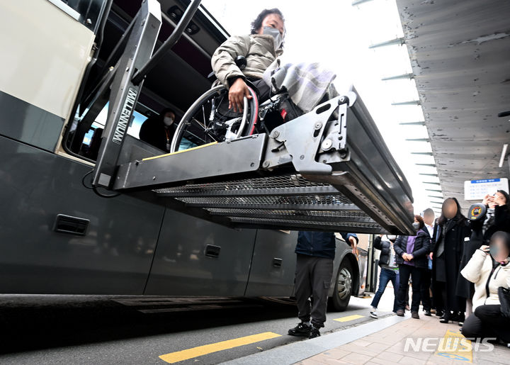 [광주=뉴시스] 변재훈 기자 = 29일 오전 광주 서구 광주종합버스터미널 앞 승강장에 정차한 특장 버스에서 휠체어 탑승 장애인이 하차하고 있다. 광주지법 제14민사부는 이날 터미널에서 '고속버스 내 휠체어 탑승 설비 미비' 차별 구제 소송과 관련 현장 검증을 벌였다. 2023.11.29. wisdom21@newsis.com