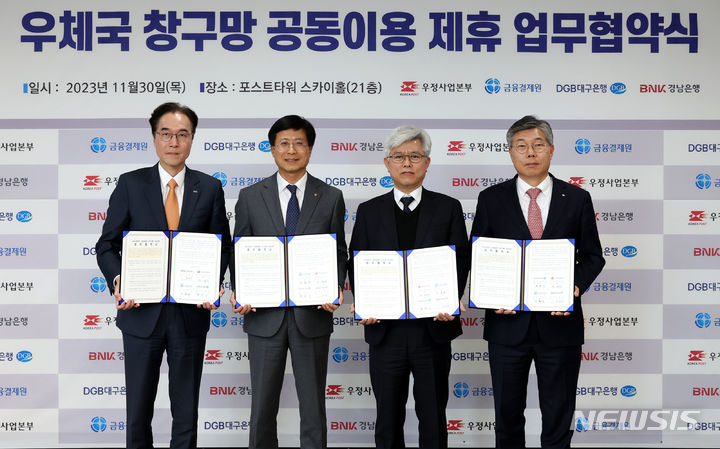 [창원=뉴시스]홍정명 기자=BNK경남은행 예경탁(왼쪽부터) 은행장이 지난달 30일 서울중앙우체국 스카이홀에서 금융결제원 박종석 원장, 우정사업본부 조해근 본부장, 대구은행 황병우 은행장과 ‘창구망 공동이용 업무협약'을 체결하고 있다.(사진=BNK경남은행 제공) 2023.12.01. photo@newsis.com