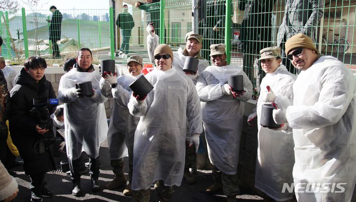 [평택=뉴시스] 사랑의 연탄나눔에 참여한 주한미군들이 기념사진을 찍고 있다. 