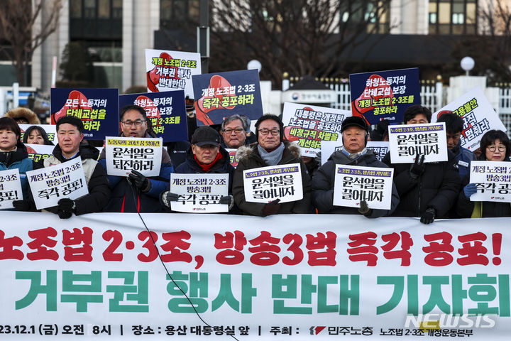 [서울=뉴시스] 정병혁 기자 = 1일 서울 종로구 정부서울청사 앞에서 열린 개정 노조법 2, 3조, 방송3법 즉각 공포 대통령 거부권 행사 반대 기자회견에서 민주노총 조합원 및 노조법 2, 3조 개정운동본부 관계자들이 피켓을 들고 있다. 2023.12.01. jhope@newsis.com