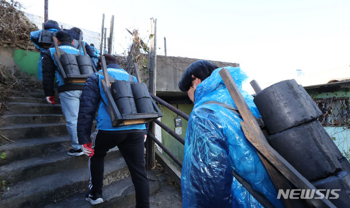 [인천=뉴시스] 전진환 기자 = 1일 오후 인천 미추홀구 학익동성당 인근에서 열린 2023년 대한민국 1도 올리기, 사랑의 연탄 나눔 행사에서 인하대 교직원과 학생들이 연탄을 각 가정으로 옮기고 있다. 2023.12.01. amin2@newsis.com