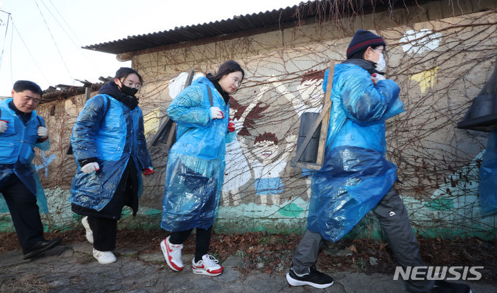 [인천=뉴시스] 전진환 기자 = 1일 오후 인천 미추홀구 학익동성당 인근에서 열린 2023년 대한민국 1도 올리기, 사랑의 연탄 나눔 행사에서 인하대 교직원과 학생들이 연탄을 각 가정으로 옮기고 있다. 2023.12.01. amin2@newsis.com