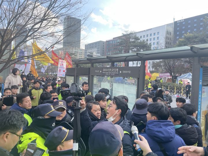 [서울=뉴시스] 임철휘 기자 = 양대노총 공공부문 노조 공동대책위원회는 2일 오후 2시 서울 영등포구 의사당대로 6개 차로에서 '민영화 저지와 노정교섭 쟁취를 위한 양대노총 공공노동자 총력투쟁 결의대회'를 개최했다. 사진은 집회가 마무리 단계에 접어든 오후 3시30분께 해당 집회를 관리하는 서울 영등포경찰서가 기준 소음을 넘겼다며 '기준 이하 소음 유지 명령서'를 집회 주최자인 현정희 위원장에게 전달하려고 하면서 조합원들과 경찰의 충돌 모습. 2023.12.02. fe@newsis.com *재판매 및 DB 금지