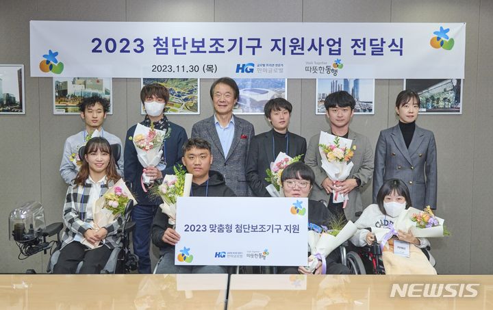 [서울=뉴시스] 따뜻한동행 2023년 첨단보조기구 전달식 모습.(뒷줄 왼쪽부터 세 번째 김종훈 따뜻한동행 이사장, 여섯 번째 김두리 따뜻한동행 본부장)