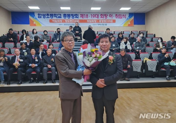 [창원=뉴시스]홍정명 기자=지난 2일 경남 마산합성초등학교 총동창회 이·취임식에서 홍정명(오른쪽) 취임회장이 정도현 이임회장에게 꽃다발을 전달하고 있다.(사진=마산합성초 총동창회 제공)2023.12.03. photo@newsis.com