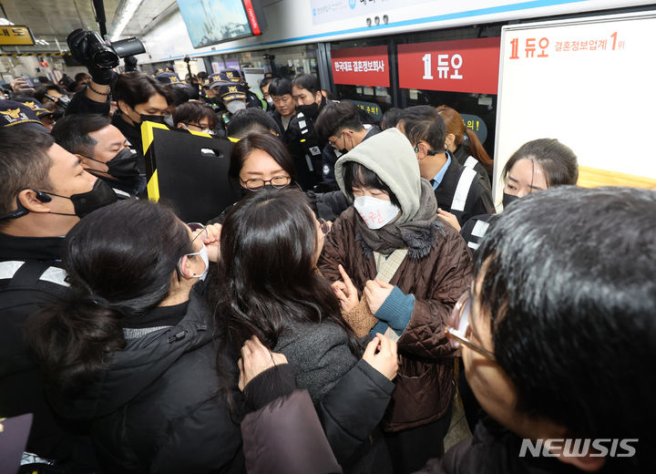 [서울=뉴시스] 김근수 기자 = 전국장애인차별철페연대(전장연)가 서울 지하철 4호선 혜화역에서 기자회견을 진행하며 서울교통공사(서교공)와 충돌이 이어지고 있는 가운데, 혜화역에서 무정차 통과가 이뤄지고 있다. 사진은 전장연이 지난 4일 오전 서울 종로구 서울지하철 4호선 혜화역에서 열린 출근길 선전전에서 역사 밖으로 강제퇴거를 당하고 있는 모습. 2023.12.04. ks@newsis.com