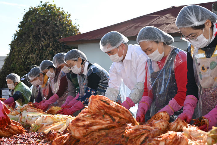 [거제=뉴시스] 신정철 기자= 박종우 거제시장(오른쪽 3번째)이 5일 일일 아주동장으로 변신, 기관단체협의회 회원들과 함께 김장을 담그고 '아주 제2근린공원' 등 주민숙원사업 현장을 점검했다.사진은 아주동 기관단체협의회 회원 50여명과 함께 불우이웃을 위한 김장을 하고 있는 모습.(사진=거제시 제공).2023.12.05. photo@newsis.com *재판매 및 DB 금지