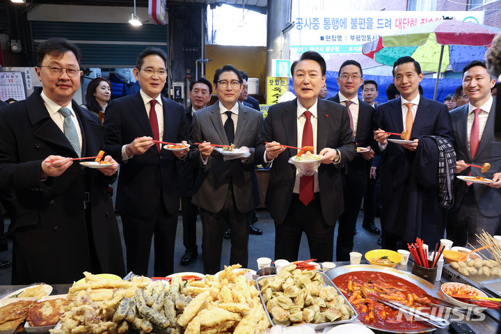 [부산=뉴시스] 전신 기자 = 윤석열 대통령이 6일 부산 중구 깡통시장을 방문해 기업인들과 떡볶이를 맛보고 있다. 왼쪽부터 최재원 SK 수석부회장, 이재용 삼성전자 회장, 조현준 효성 그룹 회장, 윤 대통령, 구광모 LG그룹 회장, 김동관 한화그룹 부회장, 정기선 HD현대 부회장. (대통령실통신사진기자단) 2023.12.06. photo1006@newsis.com