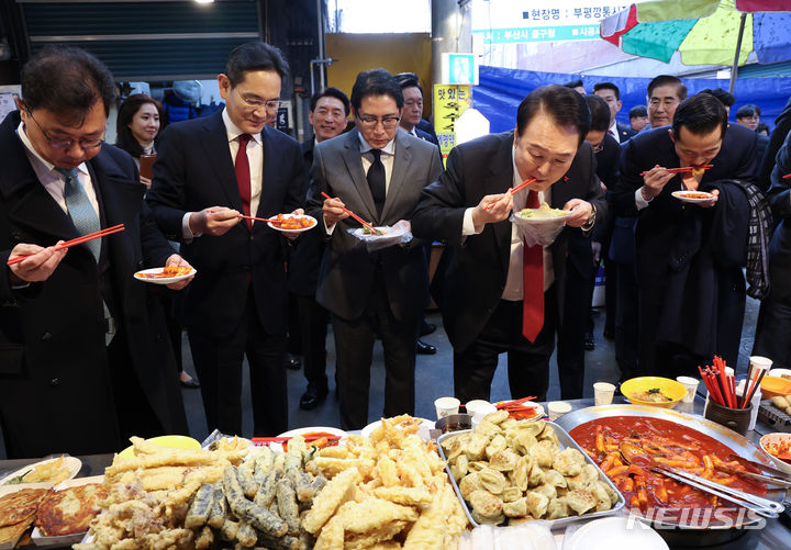 [부산=뉴시스] 전신 기자 = 윤석열 대통령이 6일 부산 중구 깡통시장을 방문해 기업인들과 떡볶이를 맛보고 있다. 왼쪽부터 최재원 SK 수석부회장, 이재용 삼성전자 회장, 조현준 효성 그룹 회장, 윤 대통령, 김동관 한화그룹 부회장.(대통령실통신사진기자단) 2023.12.06. photo1006@newsis.com