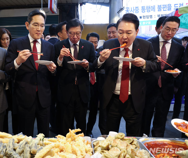 [부산=뉴시스] 전신 기자 = 윤석열 대통령이 6일 부산 중구 깡통시장을 방문해 박형준 부산시장, 기업인들과 떡볶이를 시식하고 있다. 왼쪽부터 이재용 삼성전자 회장, 박 시장, 윤 대통령, 구광모 LG그룹 회장. (대통령실통신사진기자단) 2023.12.06. photo1006@newsis.com