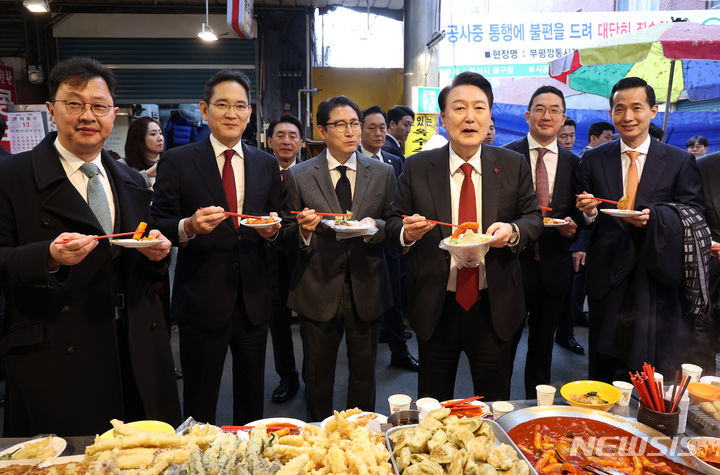 [부산=뉴시스] 전신 기자 = 윤석열 대통령이 6일 부산 중구 깡통시장을 방문해 기업인들과 떡볶이를 맛보고 있다. 왼쪽부터 최재원 SK 수석부회장, 이재용 삼성전자 회장, 조현준 효성 그룹 회장, 윤 대통령, 구광모 LG그룹 회장, 김동관 한화그룹 부회장. (대통령실통신사진기자단) 2023.12.06. photo1006@newsis.com