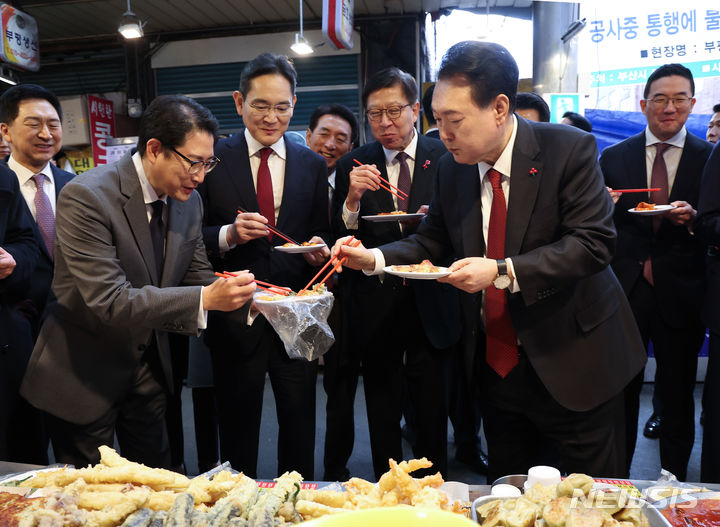 [부산=뉴시스] 전신 기자 = 윤석열 대통령이 6일 부산 중구 깡통시장을 방문해 박형준 부산시장, 기업인들과 떡볶이 등 분식을 맛보며 조현준 효성그룹 회장에게 빈대떡을 나눠주고 있다. 왼쪽부터 김기현 국민의힘 대표, 조현준 효성 그룹 회장, 이재용 삼성전자 회장, 박형준 부산시장, 윤 대통령, 구광모 LG그룹 회장. (대통령실통신사진기자단) 2023.12.06. photo1006@newsis.com