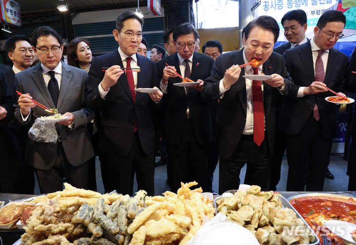 [부산=뉴시스] 전신 기자 = 윤석열 대통령이 6일 부산 중구 깡통시장을 방문해 기업인들과 떡볶이를 맛보고 있다. 왼쪽부터 조현준 효성 그룹 회장, 이재용 삼성전자 회장, 박형준 부산시장, 윤 대통령, 구광모 LG그룹 회장. (대통령실통신사진기자단) 2023.12.06. photo1006@newsis.com