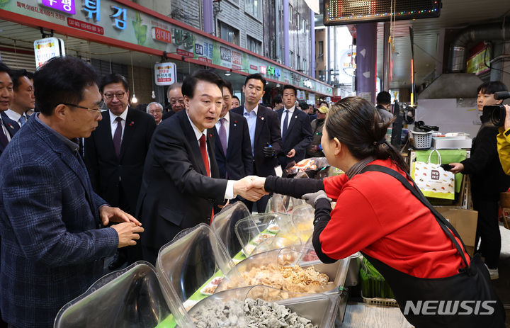 [부산=뉴시스] 전신 기자 = 윤석열 대통령이 6일 부산 중구 깡통시장을 방문해 부각전문점 상인과 악수하고 있다. (대통령실통신사진기자단) 2023.12.06. photo1006@newsis.com