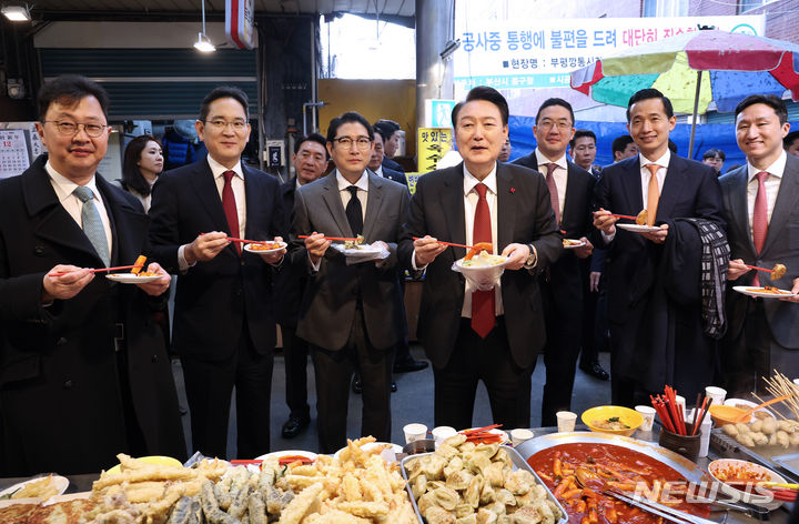 [부산=뉴시스] 전신 기자 = 윤석열 대통령이 6일 부산 중구 깡통시장을 방문해 기업인들과 떡볶이를 맛보고 있다. 왼쪽부터 최재원 SK 수석부회장, 이재용 삼성전자 회장, 조현준 효성 그룹 회장, 윤 대통령, 구광모 LG그룹 회장, 김동관 한화그룹 부회장, 정기선 HD현대 부회장. (대통령실통신사진기자단) 2023.12.06. photo1006@newsis.com