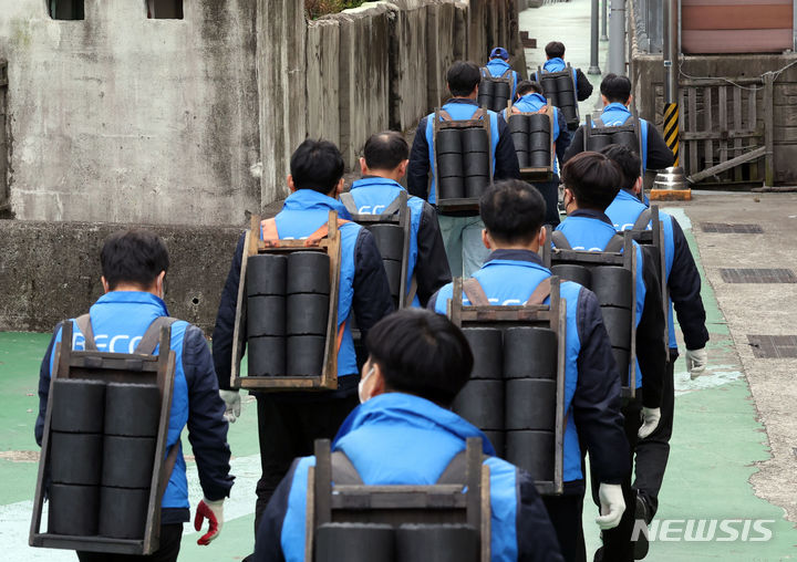 [부산=뉴시스] 하경민 기자 = 6일 부산 동구 좌천동의 한 마을에서 부산환경공단 임직원들이 소외계층 가구에 연탄을 배달하고 있다. 부산환경공단은 이날 연탄 4000장을 35가구에 전달했다. 2023.12.06. yulnetphoto@newsis.com