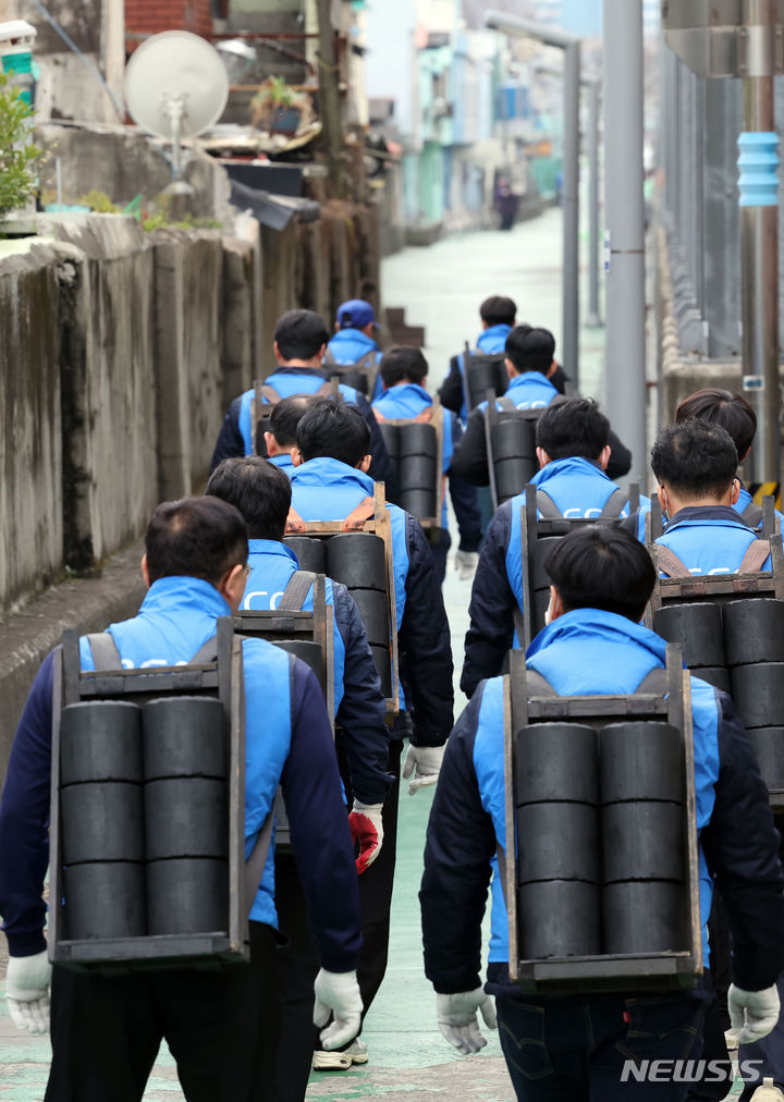 [부산=뉴시스] 하경민 기자 = 6일 부산 동구 좌천동의 한 마을에서 부산환경공단 임직원들이 소외계층 가구에 연탄을 배달하고 있다. 부산환경공단은 이날 연탄 4000장을 35가구에 전달했다. 2023.12.06. yulnetphoto@newsis.com