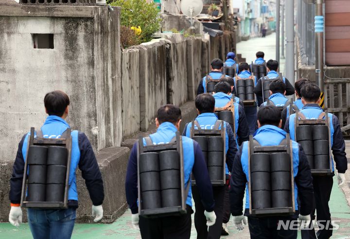 [부산=뉴시스] 하경민 기자 = 6일 부산 동구 좌천동의 한 마을에서 부산환경공단 임직원들이 소외계층 가구에 연탄을 배달하고 있다. 부산환경공단은 이날 연탄 4000장을 35가구에 전달했다. 2023.12.06. yulnetphoto@newsis.com