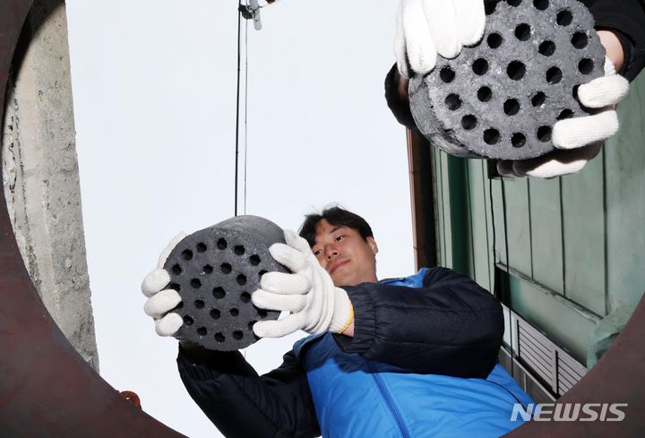 [부산=뉴시스] 하경민 기자 = 6일 부산 동구 좌천동의 한 마을에서 부산환경공단 직원들이 소외계층의 집 보관함에 연탄을 채우고 있다. 부산환경공단은 이날 연탄 4000장을 35가구에 전달했다. 2023.12.06. yulnetphoto@newsis.com