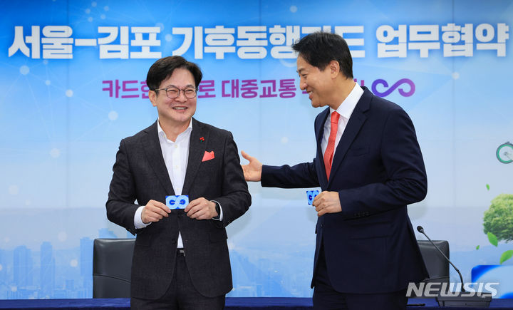 [서울=뉴시스] 조성우 기자 = 오세훈 서울시장(오른쪽)과 김병수 김포시장이 7일 오전 서울 중구 서울시청에서 열린 서울시-김포시 기후동행카드 참여 업무협약식에서 기후동행카드를 들고 기념촬영을 하다 미소짓고 있다. (공동취재) 2023.12.07. photo@newsis.com
