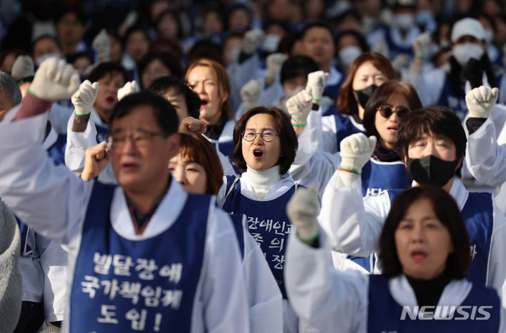 [서울=뉴시스] 김진아 기자 = 전국장애인부모연대, 서울장애인부모연대 관계자들이 7일 서울 종로구 정부서울청사 앞에서 열린 전국 오체투지 보고대회 및 서울 오체투지 선포식에서 구호를 외치고 있다. 이들은 '차별없는 세상, 완전한 통합사회 구축'이라는 슬로건 아래, 발달장애인이 자립 생활할 권리, 통합교육을 받을 권리, 노동할 권리 등을 촉구하며 제주에서 서울까지 전국 각지에서 오체투지 행진을 진행했다. 2023.12.07. bluesoda@newsis.com