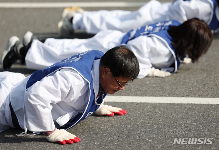 [서울=뉴시스] 김진아 기자 = 서울장애인부모연대 관계자들이 7일 서울 종로구 정부서울청사 앞에서 열린 전국 오체투지 보고대회 및 서울 오체투지 선포식을 마친 후 서울시청으로 오체투지 행진을 하고 있다. 전국장애인부모연대는 '차별없는 세상, 완전한 통합사회 구축'이라는 슬로건 아래, 발달장애인이 자립 생활할 권리, 통합교육을 받을 권리, 노동할 권리 등을 촉구하며 제주에서 서울까지 전국 각지에서 오체투지 행진을 진행했다. 2023.12.07. bluesoda@newsis.com