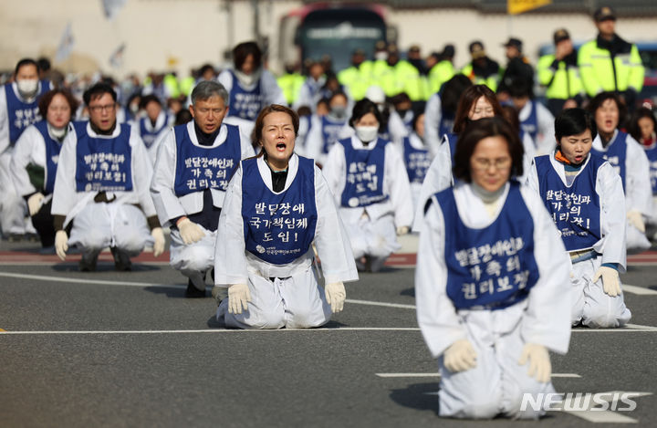 [서울=뉴시스] 김진아 기자 = 서울장애인부모연대 관계자들이 7일 서울 종로구 정부서울청사 앞에서 열린 전국 오체투지 보고대회 및 서울 오체투지 선포식을 마친 후 서울시청으로 오체투지 행진을 하고 있다. 전국장애인부모연대는 '차별없는 세상, 완전한 통합사회 구축'이라는 슬로건 아래, 발달장애인이 자립 생활할 권리, 통합교육을 받을 권리, 노동할 권리 등을 촉구하며 제주에서 서울까지 전국 각지에서 오체투지 행진을 진행했다. 2023.12.07. bluesoda@newsis.com