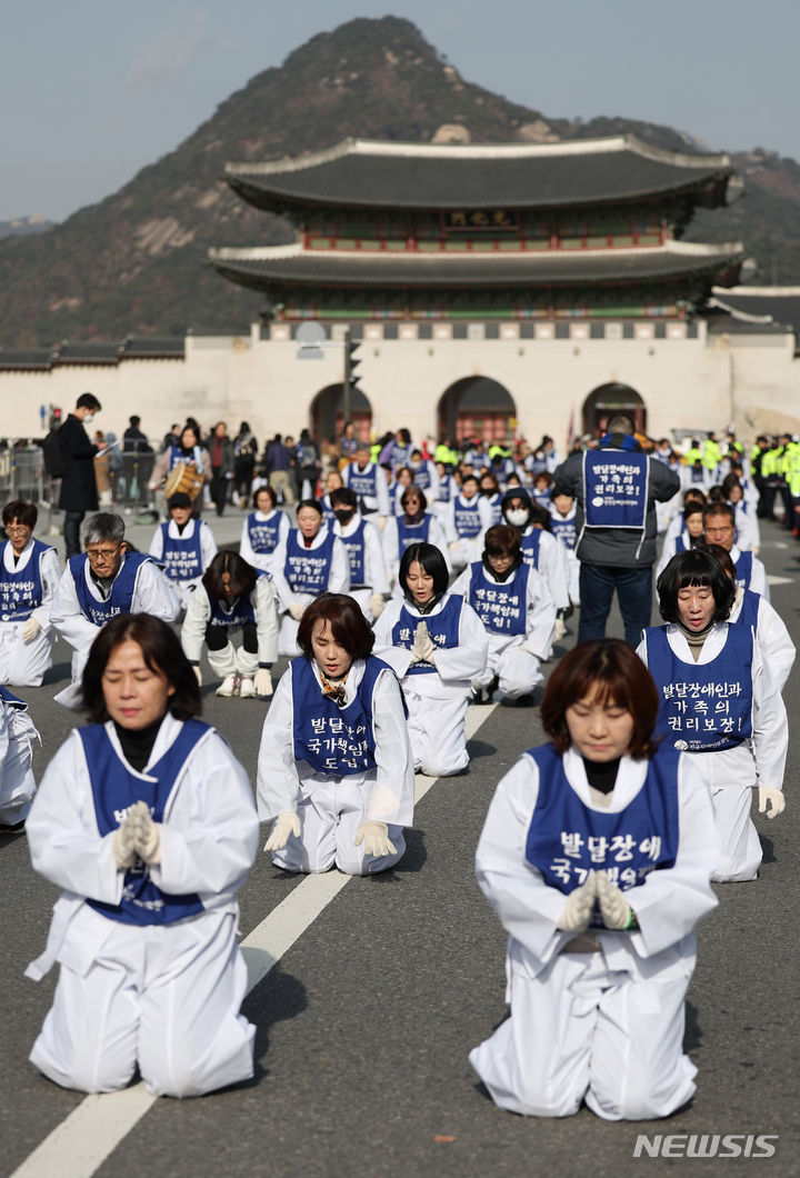 [서울=뉴시스] 김진아 기자 = 서울장애인부모연대 관계자들이 7일 서울 종로구 정부서울청사 앞에서 열린 전국 오체투지 보고대회 및 서울 오체투지 선포식을 마친 후 서울시청으로 오체투지 행진을 하고 있다. 전국장애인부모연대는 '차별없는 세상, 완전한 통합사회 구축'이라는 슬로건 아래, 발달장애인이 자립 생활할 권리, 통합교육을 받을 권리, 노동할 권리 등을 촉구하며 제주에서 서울까지 전국 각지에서 오체투지 행진을 진행했다. 2023.12.07. bluesoda@newsis.com