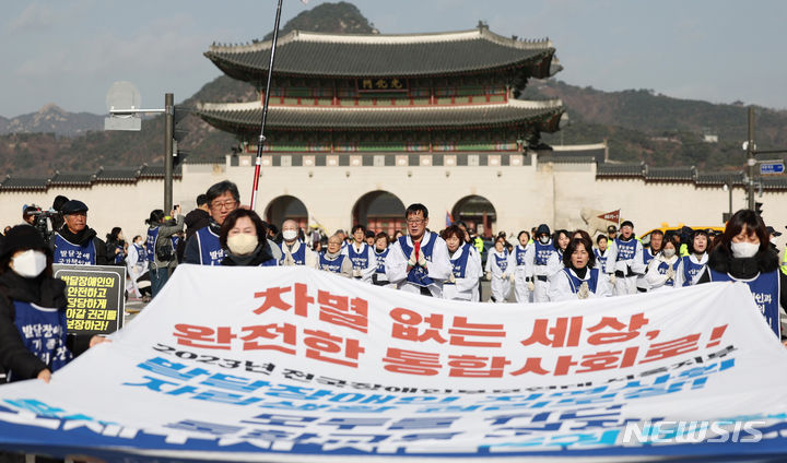 [서울=뉴시스] 김진아 기자 = 서울장애인부모연대 관계자들이 7일 서울 종로구 정부서울청사 앞에서 열린 전국 오체투지 보고대회 및 서울 오체투지 선포식을 마친 후 서울시청으로 오체투지 행진을 하고 있다. 전국장애인부모연대는 '차별없는 세상, 완전한 통합사회 구축'이라는 슬로건 아래, 발달장애인이 자립 생활할 권리, 통합교육을 받을 권리, 노동할 권리 등을 촉구하며 제주에서 서울까지 전국 각지에서 오체투지 행진을 진행했다. 2023.12.07. bluesoda@newsis.com