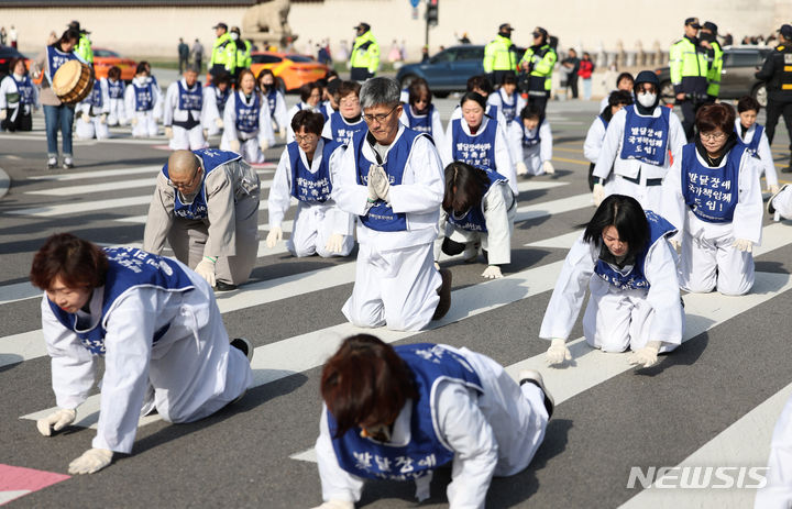 [서울=뉴시스] 김진아 기자 = 서울장애인부모연대 관계자들이 7일 서울 종로구 정부서울청사 앞에서 열린 전국 오체투지 보고대회 및 서울 오체투지 선포식을 마친 후 서울시청으로 오체투지 행진을 하고 있다. 전국장애인부모연대는 '차별없는 세상, 완전한 통합사회 구축'이라는 슬로건 아래, 발달장애인이 자립 생활할 권리, 통합교육을 받을 권리, 노동할 권리 등을 촉구하며 제주에서 서울까지 전국 각지에서 오체투지 행진을 진행했다. 2023.12.07. bluesoda@newsis.com