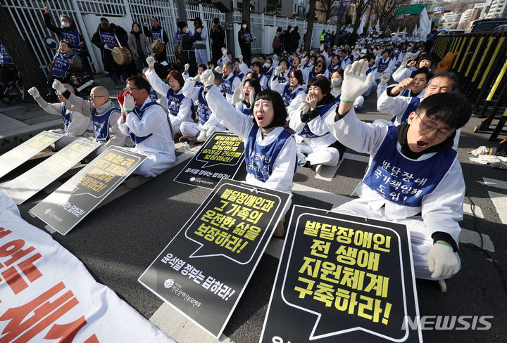 [서울=뉴시스] 김진아 기자 = 전국장애인부모연대, 서울장애인부모연대 관계자들이 7일 서울 종로구 정부서울청사 앞에서 열린 전국 오체투지 보고대회 및 서울 오체투지 선포식에서 구호를 외치고 있다. 이들은 '차별없는 세상, 완전한 통합사회 구축'이라는 슬로건 아래, 발달장애인이 자립 생활할 권리, 통합교육을 받을 권리, 노동할 권리 등을 촉구하며 제주에서 서울까지 전국 각지에서 오체투지 행진을 진행했다. 2023.12.07. bluesoda@newsis.com