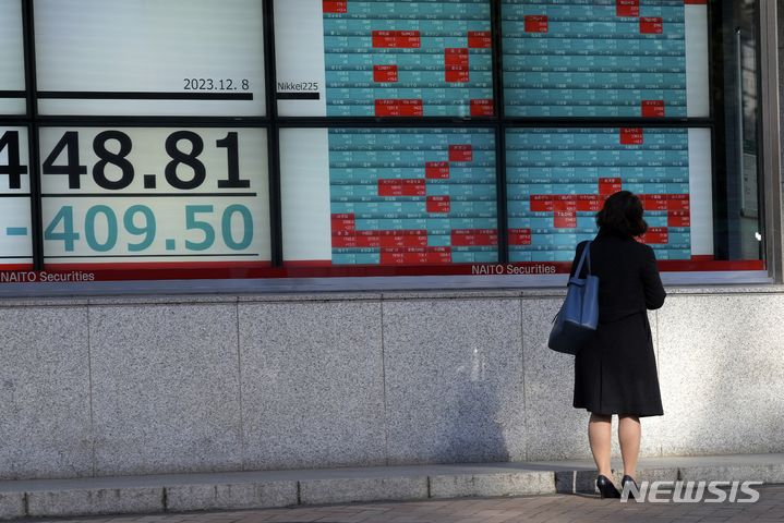 [도쿄=AP/뉴시스]한 사람이 8일 도쿄의 한 증권사에서 닛케이225지수를 보여주는 주식 시황판을 보고 있다. 2023.12.08.