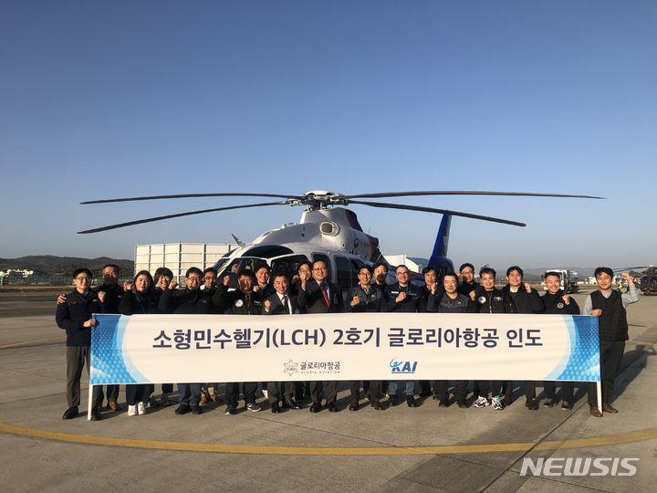 [서울=뉴시스]LCH 양산 2호기 앞에서 관계자들이 사진을 찍고 있다. 앞줄 오른쪽부터 7번째 KAI 박진석 회전익사업관리실장, 8번째 글로리아항공 신대현 대표이사.(사진=KAI 제공)