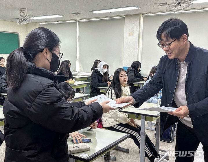 [대구=뉴시스] 정재익 기자 = 2024학년도 대학수학능력시험 성적표 배부일인 8일 오전 대구 중구 경북여자고등학교 교실에서 수험생들이 교사에게 성적표를 받고 있다. 2023.12.08. jjikk@newsis.com