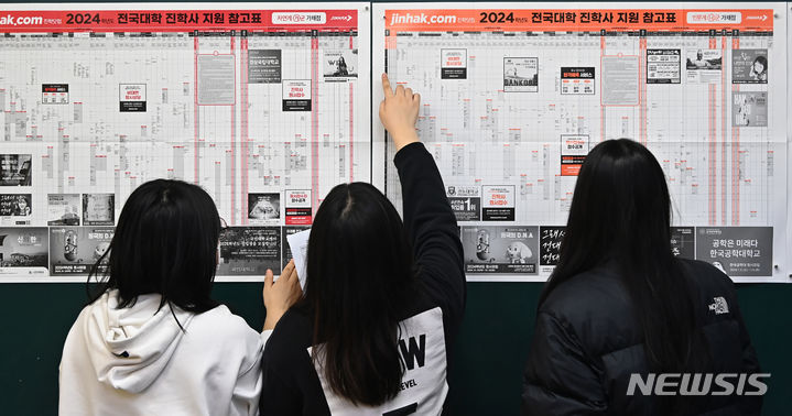 [수원=뉴시스] 김종택 기자 = 2024학년도 대학수학능력시험 성적표 배부된 8일 경기도 수원시 효원고등학교 3학년 교실에서 수험생들이 전국대학 지원 참고표를 살펴보고 있다. 2023.12.08. jtk@newsis.com