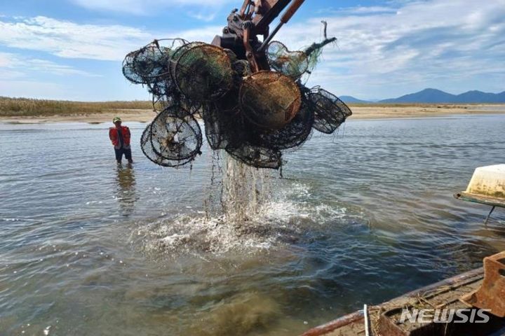[서울=뉴시스] 낙동강 무인도에서 쓰레기를 수거하는 모습. (사진=해양수산부 제공)
