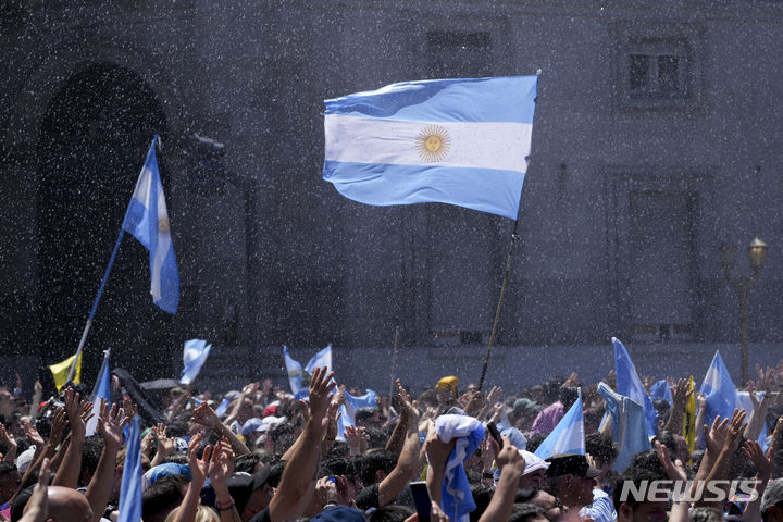 [부에노스아이레스=AP/뉴시스] 하비에르 밀레이 아르헨티나 신임 대통령의 지지자들이 10일(현지시각) 대통령 취임식이 열리는 부에노스아이레스 정부 청사 밖에서 소방관들이 뿌리는 물을 맞으며 모여 있다. 2023.12.11.