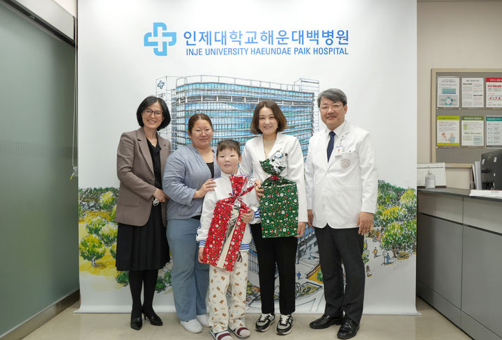 [부산=뉴시스] 몽골 소년 샤를밭이 퇴원을 앞두고 해운대백병원 의료진과 기념 사진을 촬영하고 있다. (사진=해운대백병원 제공) *재판매 및 DB 금지