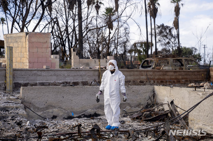 [하와이=AP/뉴시스] 미국 하와이 라하이나 홍완지 선교회의 히로나카 아이 목사가 화재로 소실된 교회 건물 앞에 서 있는 모습. 2023.12.12.