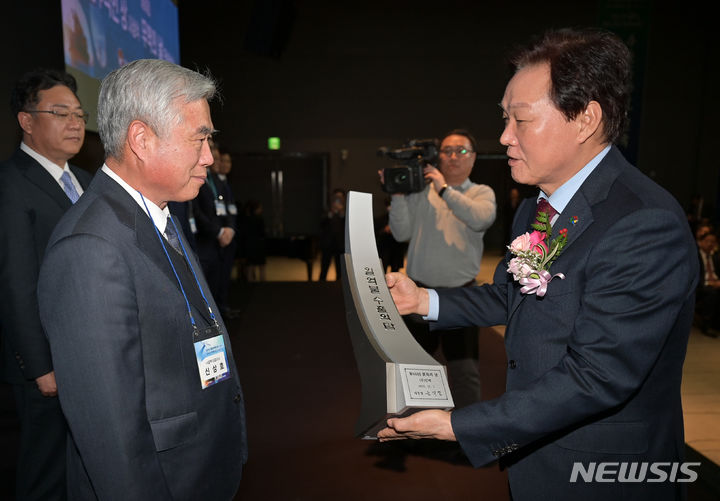 [창원=뉴시스]홍정명 기자=박완수(오른쪽) 경남도지사가 12일 오후 창원 그랜드머큐어앰배서더 호텔에서 ㈜알멕 신상호 대표이사에게 일억불 수출의 탑을 전수하고 있다.(사진=경남도 제공)2023.12.12. photo@newsis.com