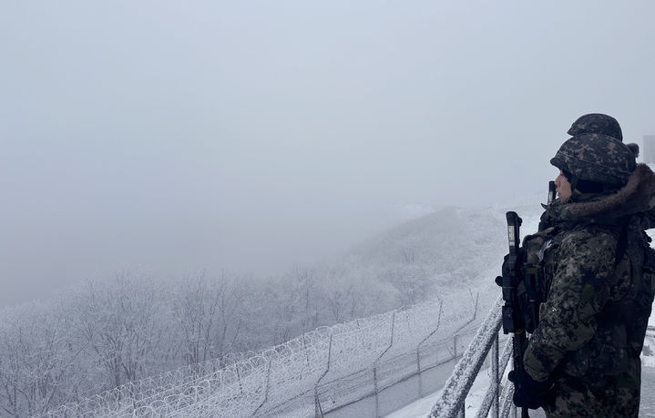 [서울=뉴시스] 육군 21사단 GOP 장병들이 12일 전방 철책을 바라보며 경계근무를 서고 있다. 육군에서 가장 높은 곳에 위치한 관측소인 해발 1242m의 가칠봉에는 밤새 11cm의 눈이 내렸다. (사진=국방부 제공) 2023.12.12. photo@newsis.com *재판매 및 DB 금지