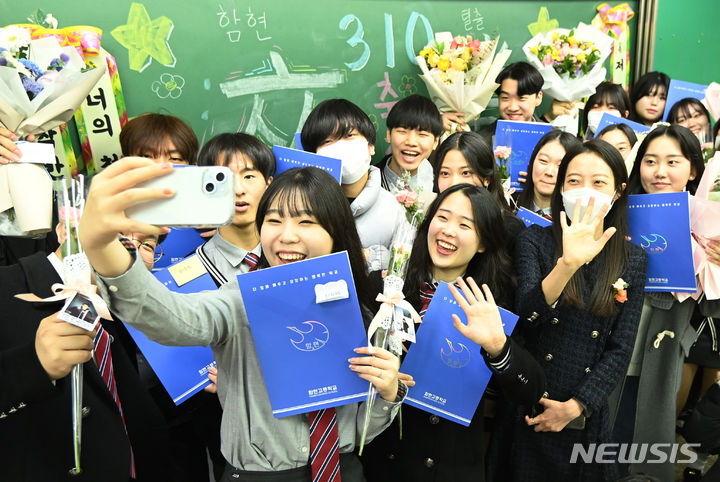 [시흥=뉴시스] 김종택 기자 = 12일 경기도 시흥시 함현고등학교에서 열린 졸업식에서 학생들이 선생님과 함께 기념촬영 하며 추억을 남기고 있다. 2023.12.12. jtk@newsis.com