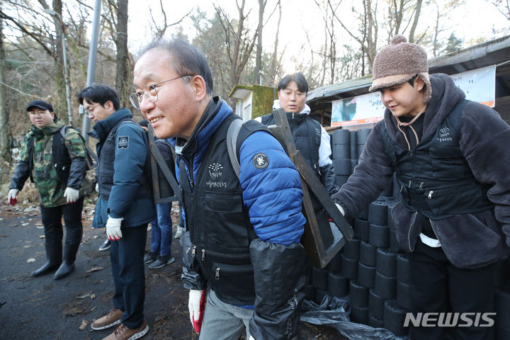 [서울=뉴시스] 고승민 기자 = 윤재옥 국민의힘 원내대표가 12일 서울 구룡마을에서 연탄배달 봉사를 하고 있다. (공동취재) 2023.12.12. photo@newsis.com