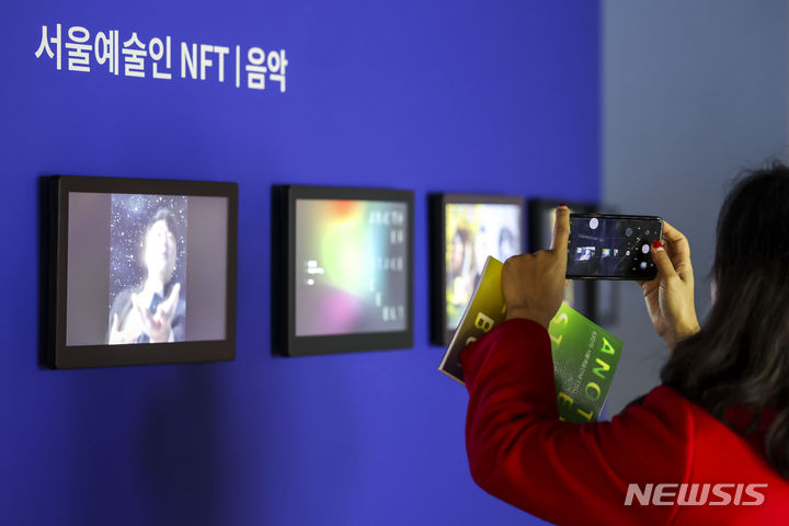 [서울=뉴시스] 정병혁 기자 = 지난해 12월 12일 서울 종로구 세화미술관에서 열린 서울예술인 63인의 NFT 작품 전시 '어나더 스테이지 데뷔'를 찾은 참여작가 및 관람객들이 작품을 살펴보고 있다. 2023.12.12. jhope@newsis.com