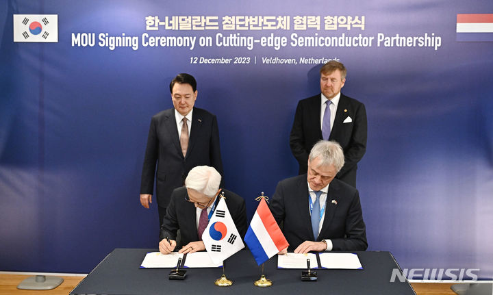 [벨트호벤=뉴시스] 조수정 기자 = 네덜란드를 국빈 방문한 윤석열 대통령과 빌럼 알렉산더르 국왕이 배석한 가운데 12일(현지시간) 벨트호벤 반도체장비 생산기업 기업인 ASML 본사에서 열린 삼성전자와 ASML간 반도체 기업 메모리 반도체용 차세대 EU 기술협력 협약(MOU) 체결식에서 경계현 삼성전자 사장과 피터 베닝크 ASML 회장이 서명을 하고 있다. 2023.12.12. chocrystal@newsis.com